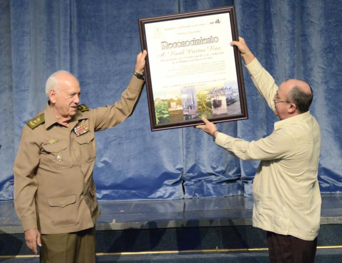 Acto por el aniversario 55 de Planificación física. Samuel Rodiles Planas (General de División y Presidente del IPF) entrega reconocimiento a Raúl Castro. Recibe Darío Delgado (Fiscal General de la República de Cuba)