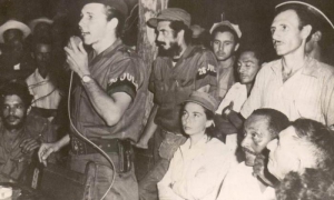 Primer congreso campesino en armas, celebrado el 21 de septiembre en Soledad de Mayarí, en territorio del II Frente guerrillero. En la foto Raúl Castro haciendo uso de la palabra, Vilma Espín sentada tras él y otros guerrilleros y campesinos (José Ramirez