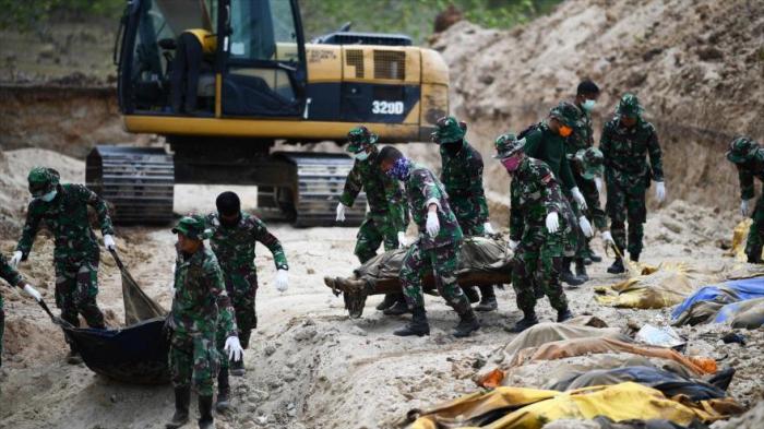 Soldados indonesios entierran a las víctimas del terremoto y tsunami en una fosa común en las afueras de Palu, en la isla de Sulawesi.