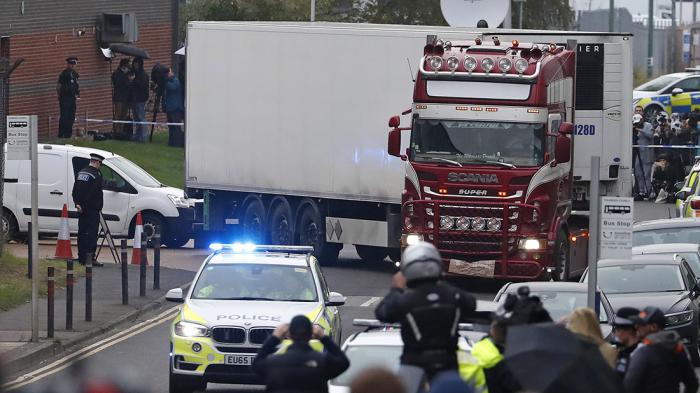 La policía escolta a un camión en donde encontraron varios cadáveres en un parque industrial en Thurrock, Inglaterra, el miércoles 23 de octubre de 2019. (AP Foto/Alastair Grant)