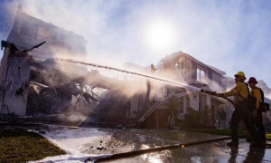 Varios bomberos apagan las llamas de una casa cerca de Santa Clarita (California).