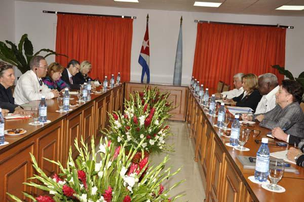 Ban Ki-moon a la izquierda, al centro macetas con floresy al fondo la bandera cubana, y a la derecha entre persona se visualiza a Esteban Lazo 