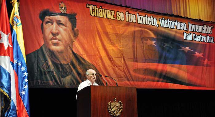 Machado Ventura hablando y atrás un enorme imagen de Chávez con una cita de Raúl Castro Ruz que dice: 