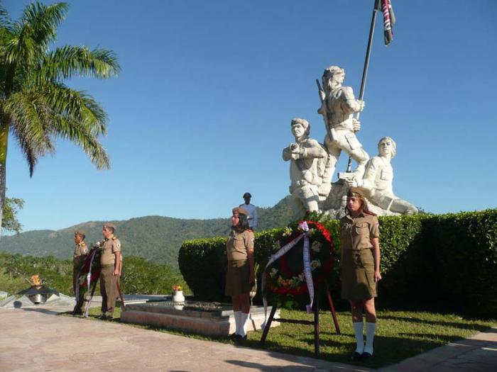 Guardias y ofrenda floral ante una tumba.