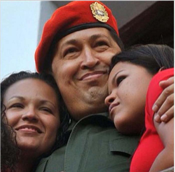 Hugo Chávez con una boina roja abrazando a sus hijas.