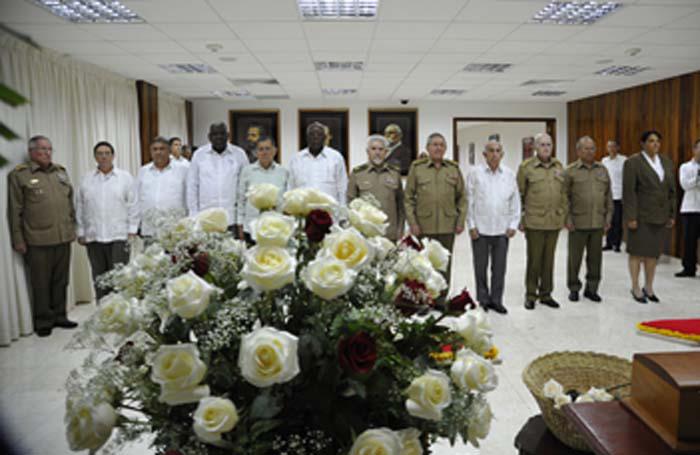 Raúl Castro y dirigentes honran a Melba Hernández. Un ramo de rosas blancas en la parte delantera de la foto.