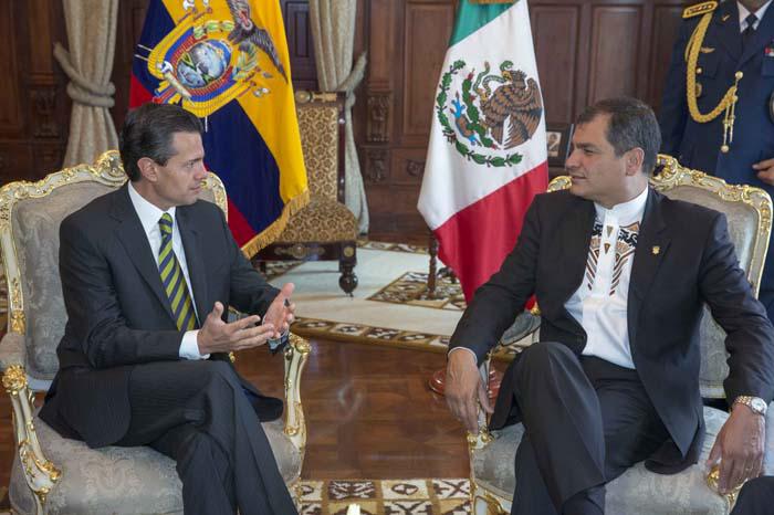 Enrique Peña Nieto y Rafael Correa conversan, detrás de ellos se observan las banderas de sus respectivos países.