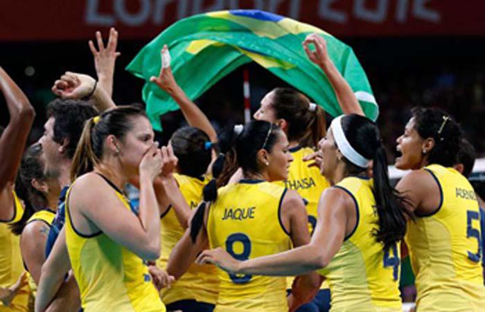 Jugadoras ondean una bandera brasileña.