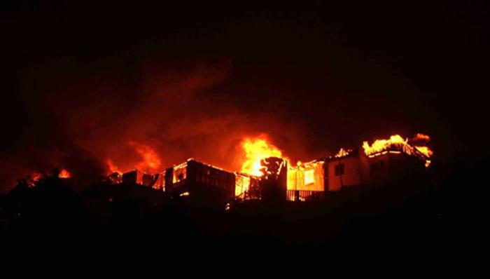 Houses burn in flames in Valparaiso, 110 km west of Santiago, Chile, on April 12, 2014. Authorities decreed a red alert for the area after the fire consumed more than 100 houses.   AFP PHOTO / FELIPE GAMBOA