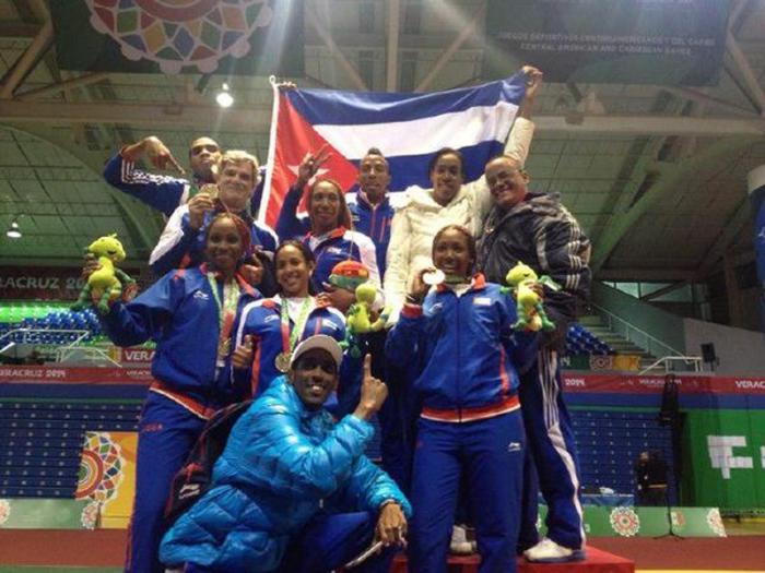 Equipo de Esgrima de Cuba. Las espadistas (al centro) festejan su triunfo junto a sus homólogos y el entrenador Pedro Enríquez (arriba a la izquierda).
