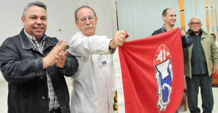 Acto central  por la fundación de la CTC en el Centro  Inmunología Molecular. Ulises Guilarte, secretario general de la CTC entrega a Agustín Lage, Director del Centro recibió la Bandera, en la foto Pedro Ross Leal quien fuera secretario de la CTC y el dirigente de base sindical.
