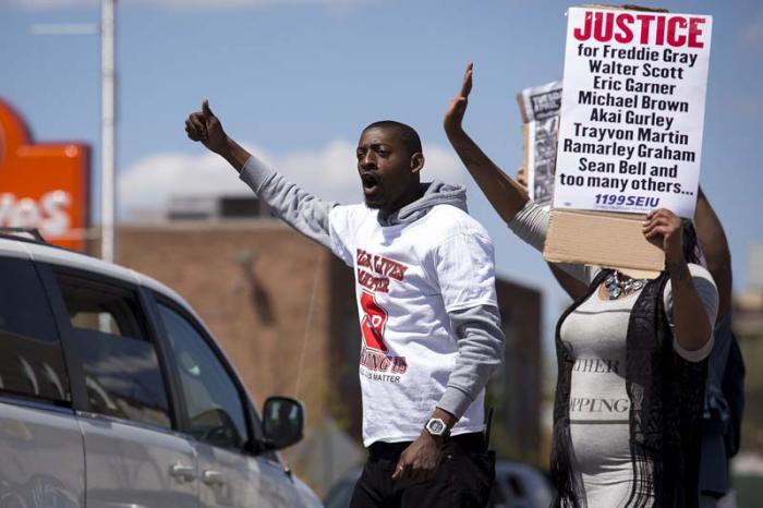 BALTIMORE, MD - APRIL 26: Protestors encourage passing cars to honk while standing in the middle of York Road near Vaughn Greene Funeral Services during the wake of Freddie Gray, April 26, 2015 in Baltimore, Maryland. Funeral services for Gray, who died last April 16, while in police custody, will be held the morning of April 27, at New Shiloh Baptist Church. (Drew Angerer/Getty Images/AFP