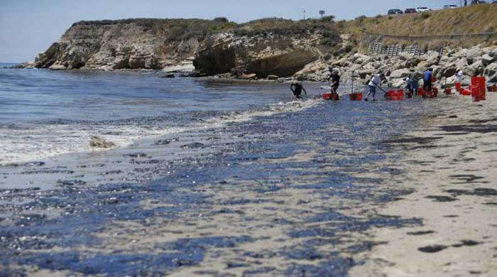 Volunteers carry buckets of oil from an oil slick along the coast of Refugio State Beach in Goleta, California, United States, May 20, 2015. A pipeline ruptured along the scenic California coastline on Tuesday, spilling some 21,000 gallons (79,000 liters) of oil into the ocean and on beaches before it could be secured, a U.S. Coast Guard spokeswoman said. REUTERS/Lucy Nicholson