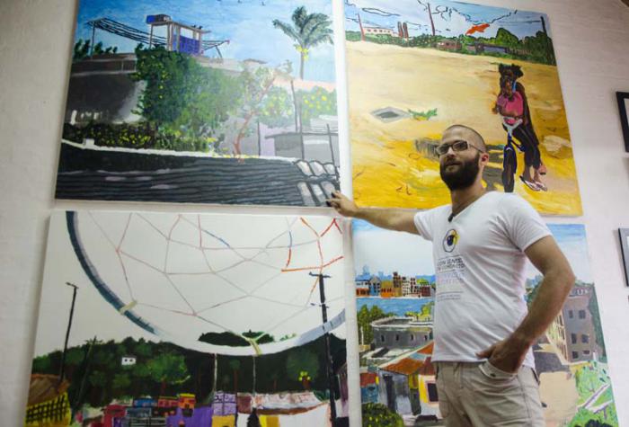 El artista plástico Fidel Yordani Zamora junto a una expo del proyecto 