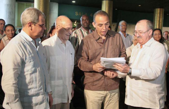 Homenaje a los juristas cubanos por su aniversario 150. Darío Delgado Cura, Fiscal General de la República de Cuba, entrega a Antonio Guerrero, Héroe de la República de Cuba ejemplares del libro 