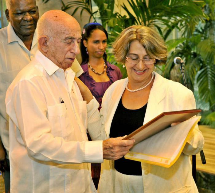 Acto de entrega del informe de los resultados de las elecciones parciales del Poder Popular por parte de la Comisiòn Nacional Electoral al Consejo de Estado, José Ramón Machado Ventura, segundo secretario del Comité Central del Partido Comunista de Cuba y vicepresidente de los Consejos de Estado y de Ministros, entrega reconocimiento a  la Presidenta del CNE Alina Valseiro