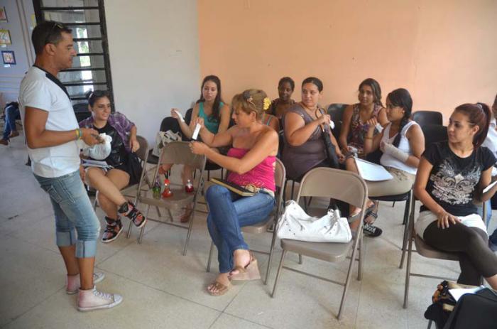 Teofilo Márquez (izq), coodrinador-profesor de maquillaje de la Casa de Orientacion a la Mujer, junto a estudiantes.