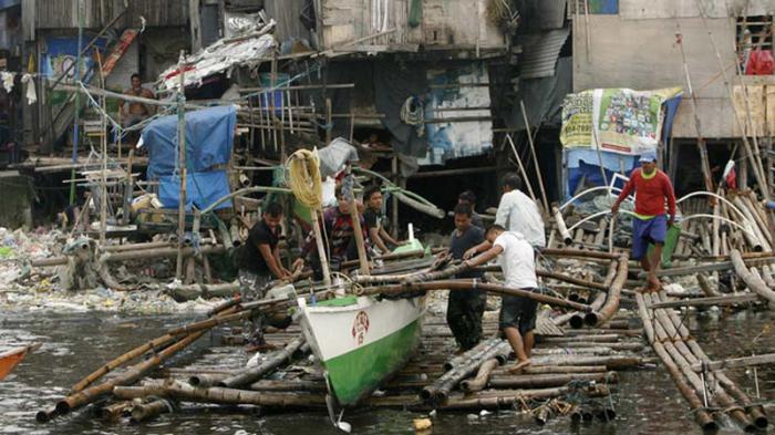 epa04889818 Filipino fishermen secure a boat at a coastal village in Navotas city, north of Manila, Philippines, 20 August 2015. State weather bureau raised Storm Warning Signals as Typhoon Goni is felt in the northern part of the country, packing maximum wind of 180 kilometers per hour, gustiness of up to 215 kilometers per hour and residents are advised to brace for more rains and possible storm surges in coastal areas in the days to come.  EPA/FRANCIS R. MALASIG