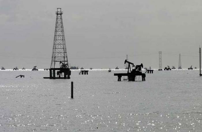 Oil rigs are seen on Lake Maracaibo from the shore in Cabimas, in Venezuela's western state of Zulia February 28, 2011. Oil prices fell on Monday in volatile trading as expectations that increased production from Saudi Arabia can offset supply disruptions in the region allowed investors to pause after Libya's turmoil sent prices to 2-1/2-year peaks last week. REUTERS/Isaac Urrutia (VENEZUELA - Tags: ENERGY BUSINESS)