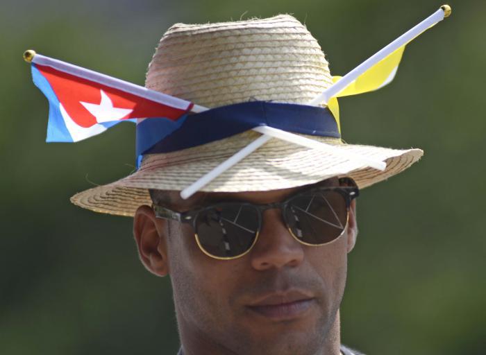 Joven con banderas de Cuba y el Vaticano