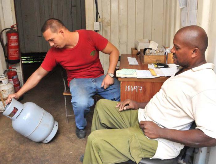 Distribución de GLP (Balitas de Gas), en 11 y C Vedado (foto Jorge Luis González) 21-10-15 Balita09N9  El técnico de distribución de GLP, Frank Valdés Moduy comprueba el Cilindro de Miguel Ángel Placeres Verdejas.