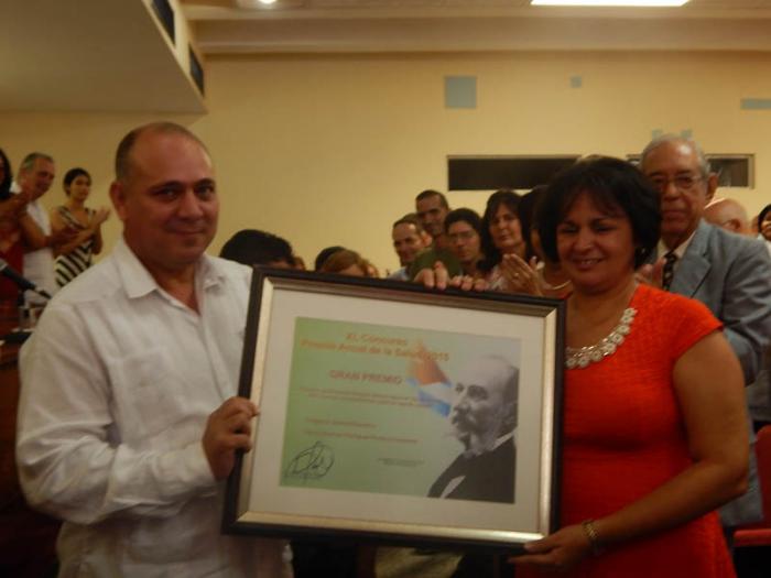 El ministro cubano de salud Roberto Morales entrega el Premio Anual de Salud a la Doctora en Ciencias Rosmeri Rodríguez Roche.