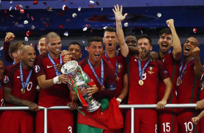 Football Soccer - Portugal v France - EURO 2016 - Final - Stade de France, Saint-Denis near Paris, France - 10/7/16 Portugal's Cristiano Ronaldo celebrates with team mates and the trophy after winning Euro 2016 REUTERS/Kai Pfaffenbach Livepic