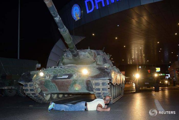 Un ciudadano se tumba ante el paso de un tanque en el aeropuerto de Estambul. foto: Reuters 