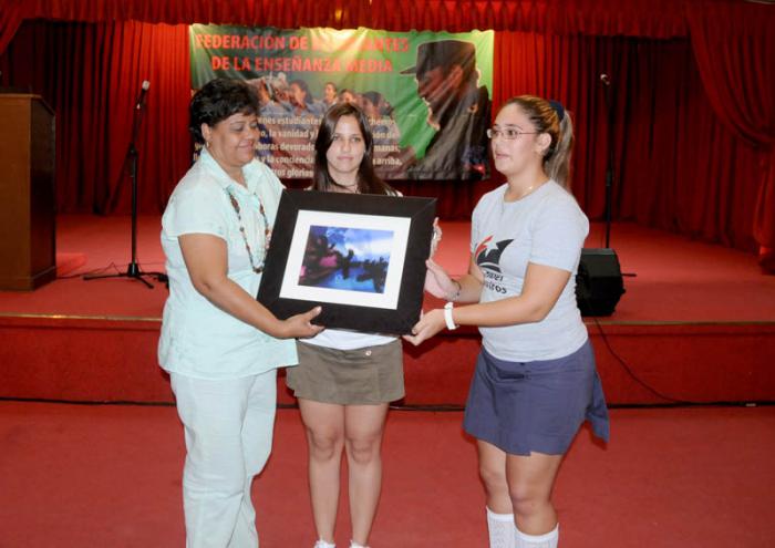 La secretaria de la FEEM entrega un regalo a Olga Lidia Tapia Iglesias para el comandante Fidel Castro Ruz