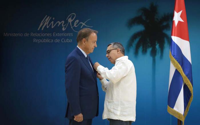 El ministro interino de Relaciones Exteriores, Marcelino Medina (derecha) le coloca la Medalla de la Amistad a Jean-Pierre Bel.