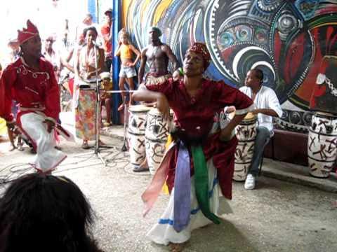 Desde una silla artesanal, la artista cubana de mayor relevancia planetaria, con 96 años recién cumplidos, marcó el ritmo de los tambores con sus pies elegantemente cruzados pero sin dejar de moverlos, mientras un grupo de bailarines folclóricos interpretaban danzas yorubas..
