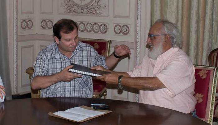 El coordinador de la Brigada Antonio Maceo, Andrés Gómez Barata (derecha), entregó el libro de condolencias a Fernando González Llort, vicepresidente del ICAP.