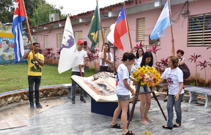 Brigadistas rinden homenaje al líder estudiantil Julio Antonio Mella en la plaza con el mismo nombre que recoge en un pedestal la biografía de quien fuera también el fundador del Partido Comunista de Cuba.