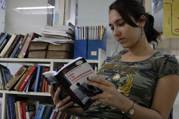 Estudiante de periodismo lee libro de Jesús Arboleya. Cuba y los Cubanoamericanos. El fenómeno migratorio cubano. 