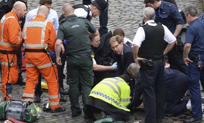 El diputado Tobias Ellwood intenta reanimar sin éxito al agente de policía apuñalado este miércoles en Londres.