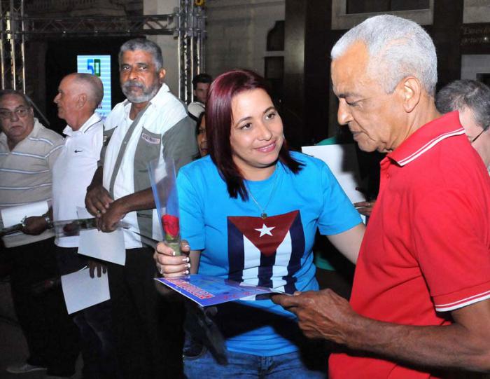 Acto político cultural y de estímulos a trabajadores de la UJC por su 55 Aniversario. Sucely Morfa González, Primera Secretaria de la Unión de Jóvenes Comunistas (UJC) entrega Certificado por 50 años a Roque Pérez La O.