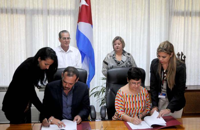 Firma de convenio de acuerdo entre Doctor en Comunicaciones Raúl Garcés decano de la Facultad de Comunicaciones de la Universidad de la Habana y Nacy Valdés Jiméneez viceministra, Ministerio  del Comercio Interior.