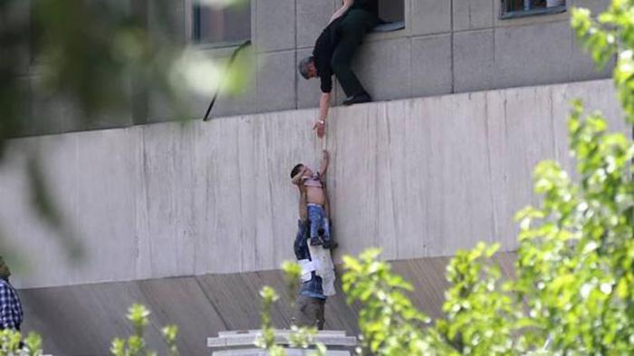 La policía iraní evacúa a un niño del Parlamento.
FOTO: AFP