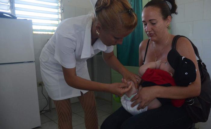 Enfermera vacunando a un bebé.
