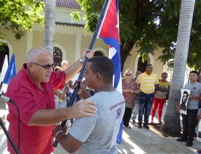 Carlos Rafael Miranda entrega la bandera cubana a Wílber Lobaina Coy, jefe del destacamento. Foto del autor
