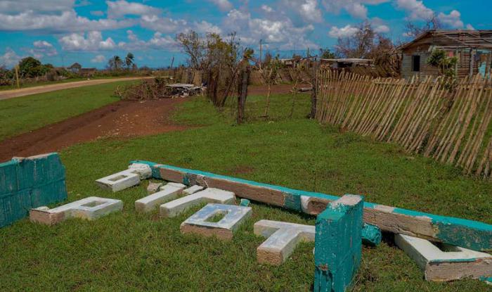 El letrero que señaliza la entrada y salida del pueblo quedó en el suelo por causa de los vientos. 