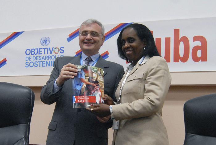 Jorge Chediek, Director de la Oficina de cooperación Sur-Sur de Naciones Unidas(Izq) entrega un ejemplar de la revista Souht-Souht in action, dedicada a experiencias cubanas de cooperación Sur-Sur a Ileana Nuñez, viceministra de Comercio Exterior e Inversión Extranjera.