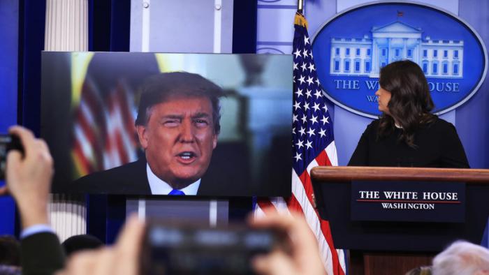 Donald Trump habla a través de una pantalla en la Casa Blanca durante una rueda de prensa junto con la vocera de la Casa Blanca, Sarah Sanders, 4 de enero de 2018. 
