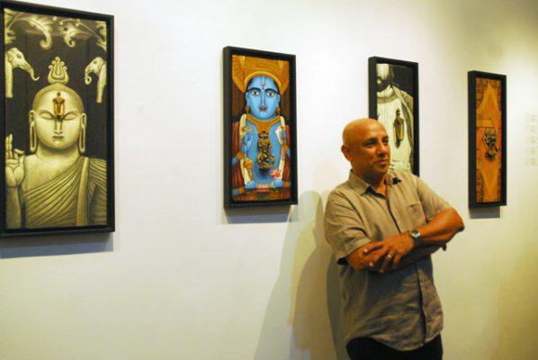 Exposición de Aristides Hernández (Ares) - Ares toca madera - Tras Ares, y a su izquierda, un Buda con una aldaba como nariz