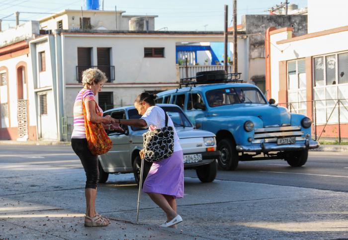 Mujeres de la tercera edad, ayudándose mutuamente en la calle Infanta en el Cerro.