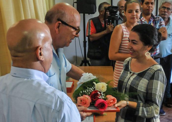 Miguel Barnes (C), presidente de la (UNEAC) entrega a la ganadora de la XVII Edición del Premio Iberoamericano de Cuento Julio Cortázar a Marta Acosta Álvarez (D) por el cuento ¨El olor de los cerezos¨ en el Centro Cultural Dulce María Loynaz, en calle 19, Vedado