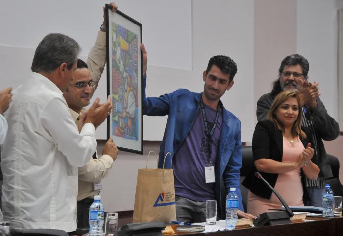 Rafael González Muñoz (C), nuevo presidente de la AHS le entrega un Reconocimiento a Rubiel García (C.I), expresidente de la AHS, durante la Clausura del 3 Congreso de la Asociación Hermanos Saíz, presiden Alpidio Alonso, ministro de cultura, Susely Morfa González, Primera Secretaria del Comité Nacional de la Unión de Jóvenes Comunistas (UJC), Roberto Montesinos, Jefe del Departamento y Propaganda del PCC, Abel Prieto, Presidente de la oficina del programa martiano, Rubiel García, presidente de las AHS Nacional, entre otros, en el Palacio de Convenciones, Playa