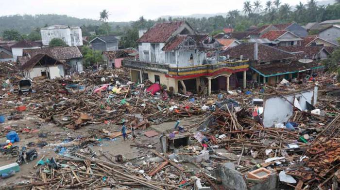 Residentes locales caminan entre los escombros en un área devastada tras un tsunami que azotó el Estrecho de Sunda en Sumur, Banten, Indonesia AFP.jpg