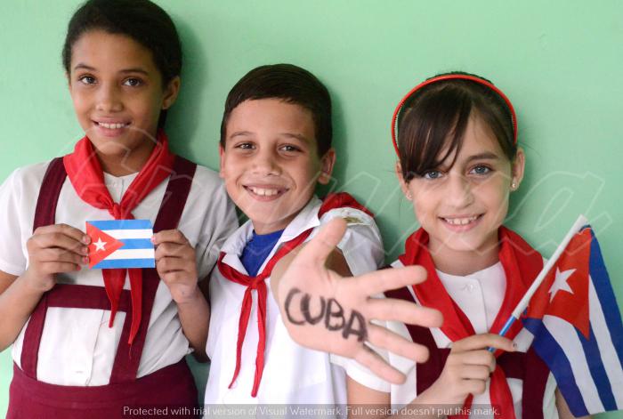 Niños con uniforme y bandera cubana