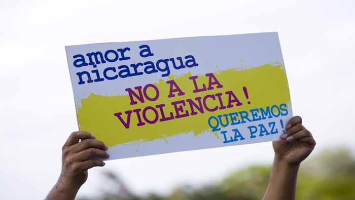 Un hombre levanta un cartel en alusión a la paz hoy, lunes 30 de abril de 2018, durante una marcha en apoyo al gobierno Si al Dialogo y no a la Violencia, en Managua - EFE
